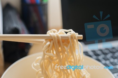 Some People Eat Noodles During Work Stock Photo