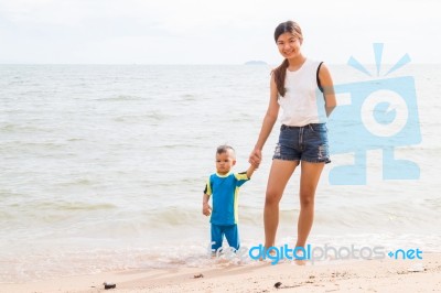 Son And Mom Chill On The Beach Stock Photo