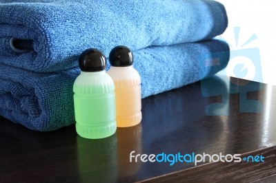 Spa Bottles And Blue Towel On Wooden Table Stock Photo