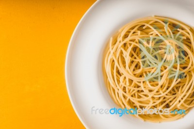 Spaghetti  On The White Plate On The Yellow Background Top View Stock Photo