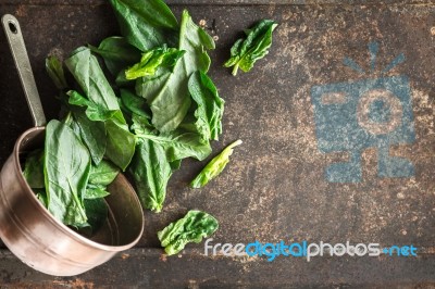 Spinach In The Copper Pt On The Metal Background Top View Stock Photo