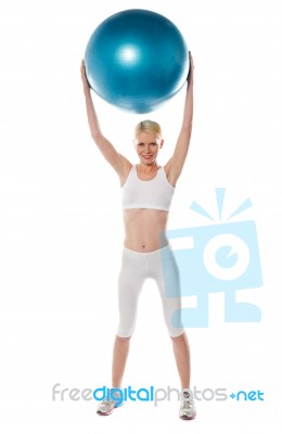 Sporty Lady Holding Ball Over Head Stock Photo