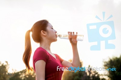 Sporty Woman Drinking Water On Sunlight Stock Photo