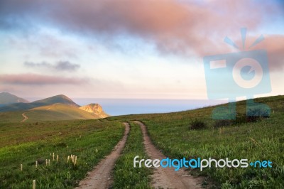 Spring Meadow In The Hills. Sea On The Background Stock Photo