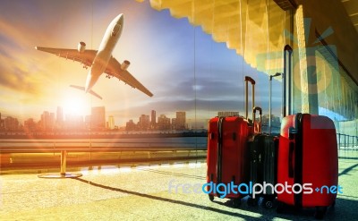 Stack Of Traveling Luggage In Airport Terminal And Passenger Plane Flying Over Building In City Stock Photo