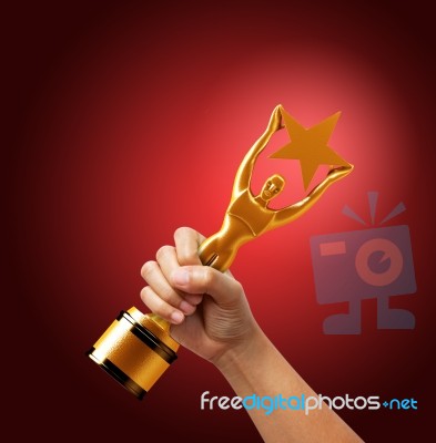 Star Award In Hand Isolated On Red Background Stock Photo