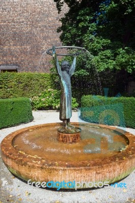 Statue Of A Man Holding A Hoop Fountain In St Gilgen Stock Photo