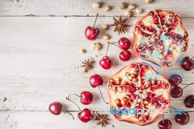 Still Life With Pomegranate , Cherry And Spices On The White Wooden Table Stock Photo