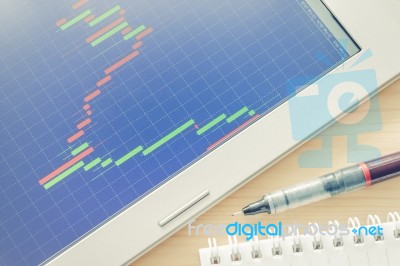 Stock Or Forex Graph Or Candlestick Chart On Blue Screen And Pen And Notebook Vintage Style Stock Photo