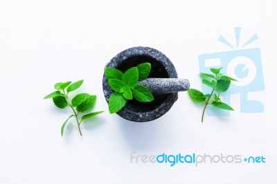 Stone Mortar And Pestle With Peppermint Leaf On White Wooden Bac… Stock Photo