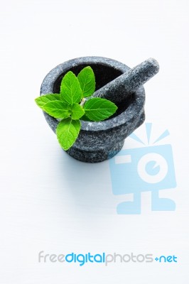 Stone Mortar And Pestle With Peppermint Leaf On White Wooden Bac… Stock Photo