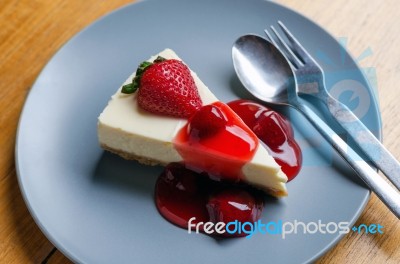 Strawberry Cheesecake With Spoon And Fork On Wooden Table Stock Photo