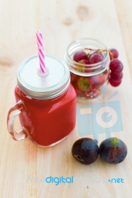 Strawberry Juice, Figs And Grapes On Wooden Background Stock Photo