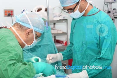 Student Assistant Helping Doctor In A Surgery Stock Photo