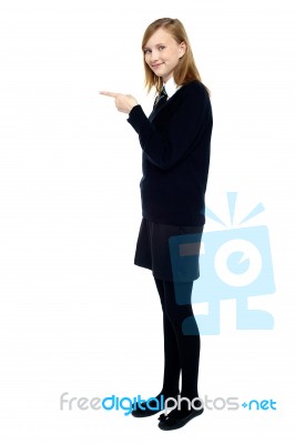 Student Standing Sideways And Pointing Forward Stock Photo