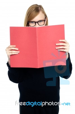 Student With A Red Book Learning Intently Stock Photo