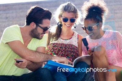 Students Group Looking At A Book In The Street Stock Photo