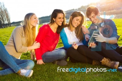 Students Having Fun With Smartphones And Tablets After Class Stock Photo