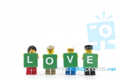 Studio Shot Of Lego Minifigure Holding Word Love On White Background Stock Photo