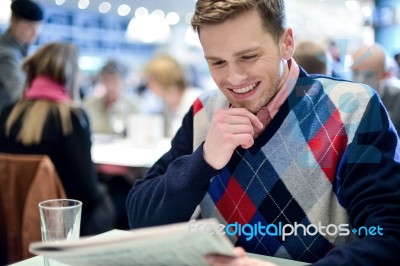 Stylish Man Reading Newspaper At Cafe Stock Photo