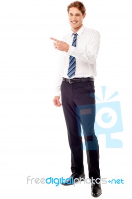 Stylish Young Businessman Pointing Away Stock Photo