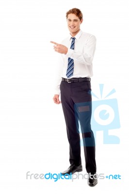 Stylish Young Businessman Pointing Away Stock Photo