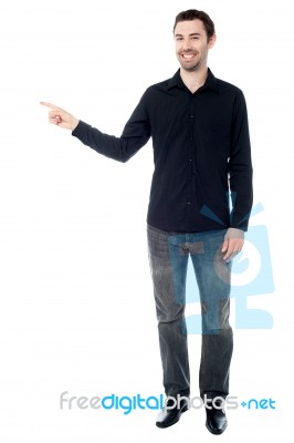 Stylish Young Guy Pointing Away Stock Photo