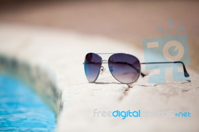 Sunglasses Over Swimming Pool Stock Photo