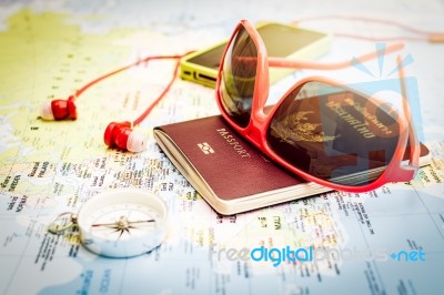 Sunglasses, Passport, Smart Phone, Earphones And Compass On The Stock Photo