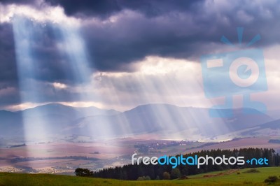 Sunlight Beams Over Clouds In Mountains. Rays In Cloudy Sky Stock Photo