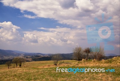 Sunny Spring In Mountain Village. Fields And Hills Stock Photo