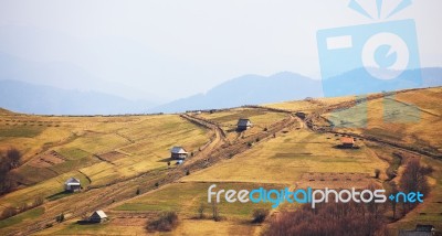 Sunny Spring In Mountain Village. Fields And Hills Stock Photo