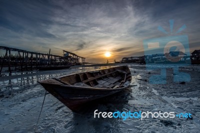 Sunrise At Seashore With Boat In Front Stock Photo