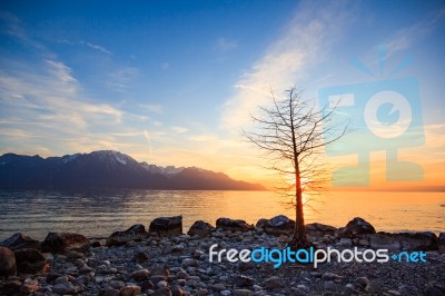 Sunset Over A Mountains Range Reflecting In A Lake Stock Photo