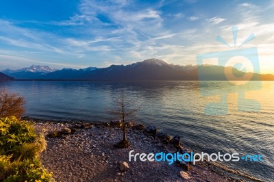 Sunset Over Mountains With A Lake And Shoreline Stock Photo