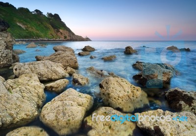 Sunset Over Rocky Coastline Stock Photo