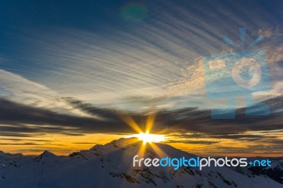 Sunset Over The Snowy White Alpine Mountains Stock Photo