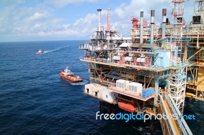 Supply Boat Transfer Cargo To Oil And Gas Industry And Moving Cargo From The Boat To The Platform Stock Photo