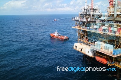 Supply Boat Transfer Cargo To Oil And Gas Industry And Moving Cargo From The Boat To The Platform Stock Photo