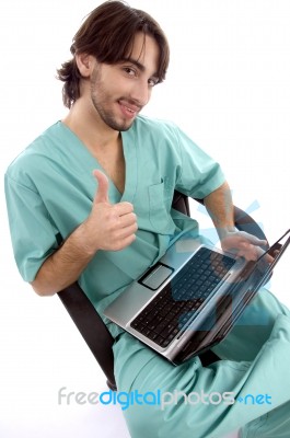 Surgeon On Laptop With Thumbs Up Stock Photo