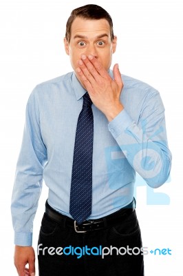 Surprised Businessman With Hand On Mouth Stock Photo