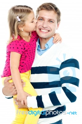 Sweet Daughter Kissing Her Smiling Father Stock Photo