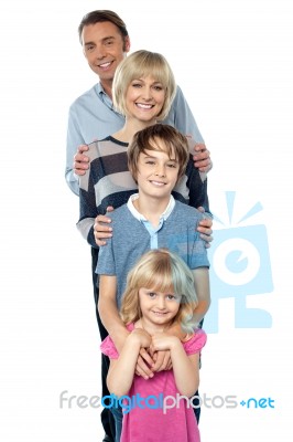 Sweet Little Family Of Four Posing One Behind The Other Stock Photo