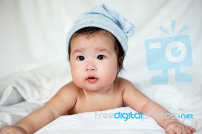 Sweet Newborn Baby In White Hat Lies On Bed Stock Photo