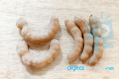 Sweet Ripe Tamarind Pods On Wood Background Stock Photo