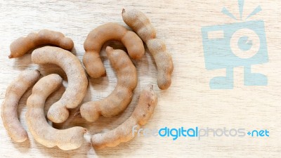 Sweet Ripe Tamarind Pods On Wood Background Stock Photo