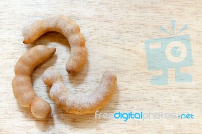 Sweet Ripe Tamarind Pods On Wood Background Stock Photo