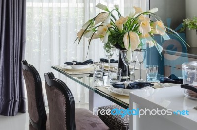 Table Set On Glass Dinning Table With Vase Of Flower Stock Photo