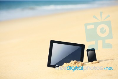 Tablet And Smartphone On The Beach Stock Photo