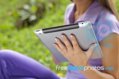 Tablet Computer On Hand Of Beautiful Young Woman In Park Stock Photo